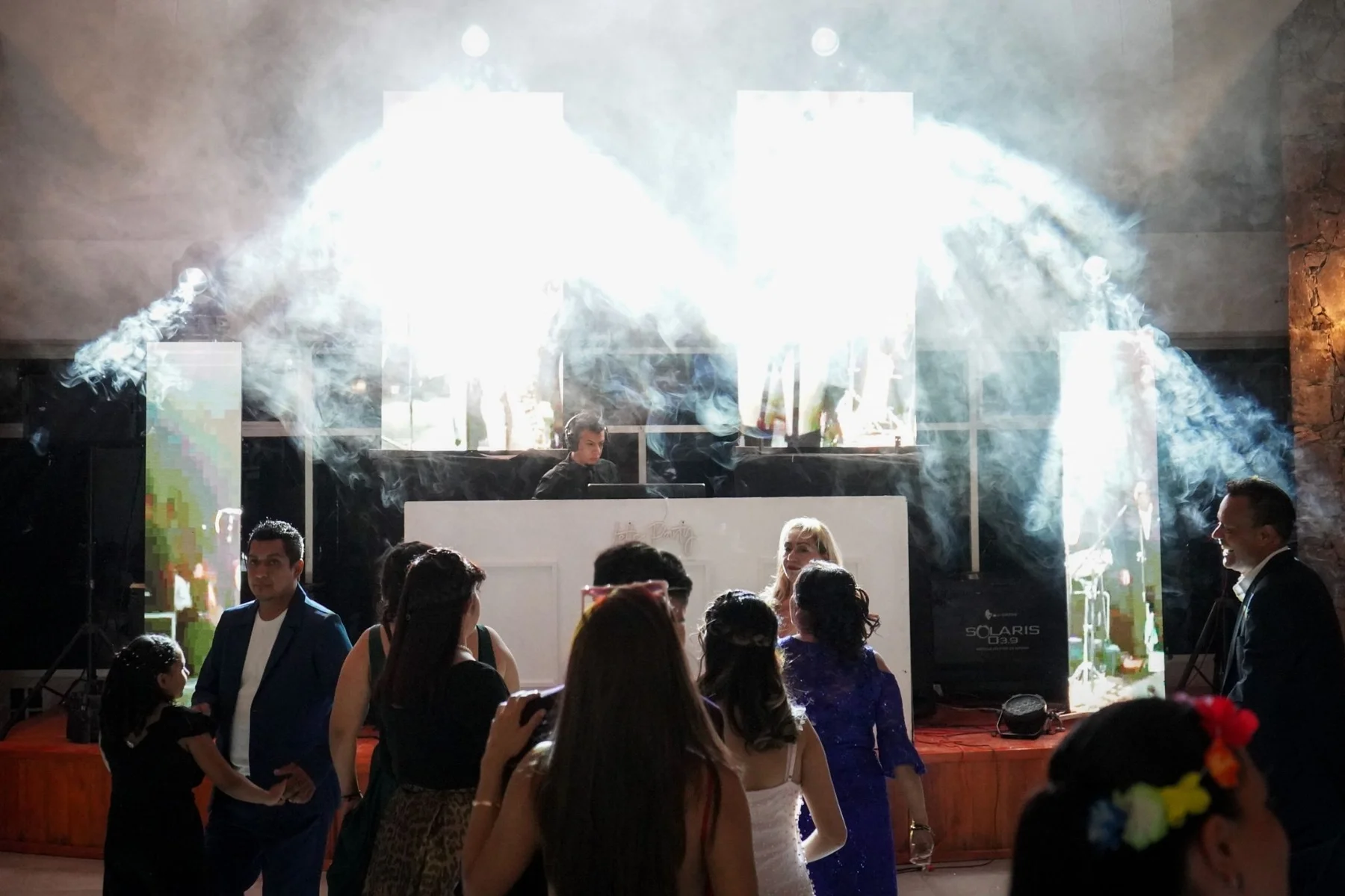 Invitados bailando bajo luces y efectos
